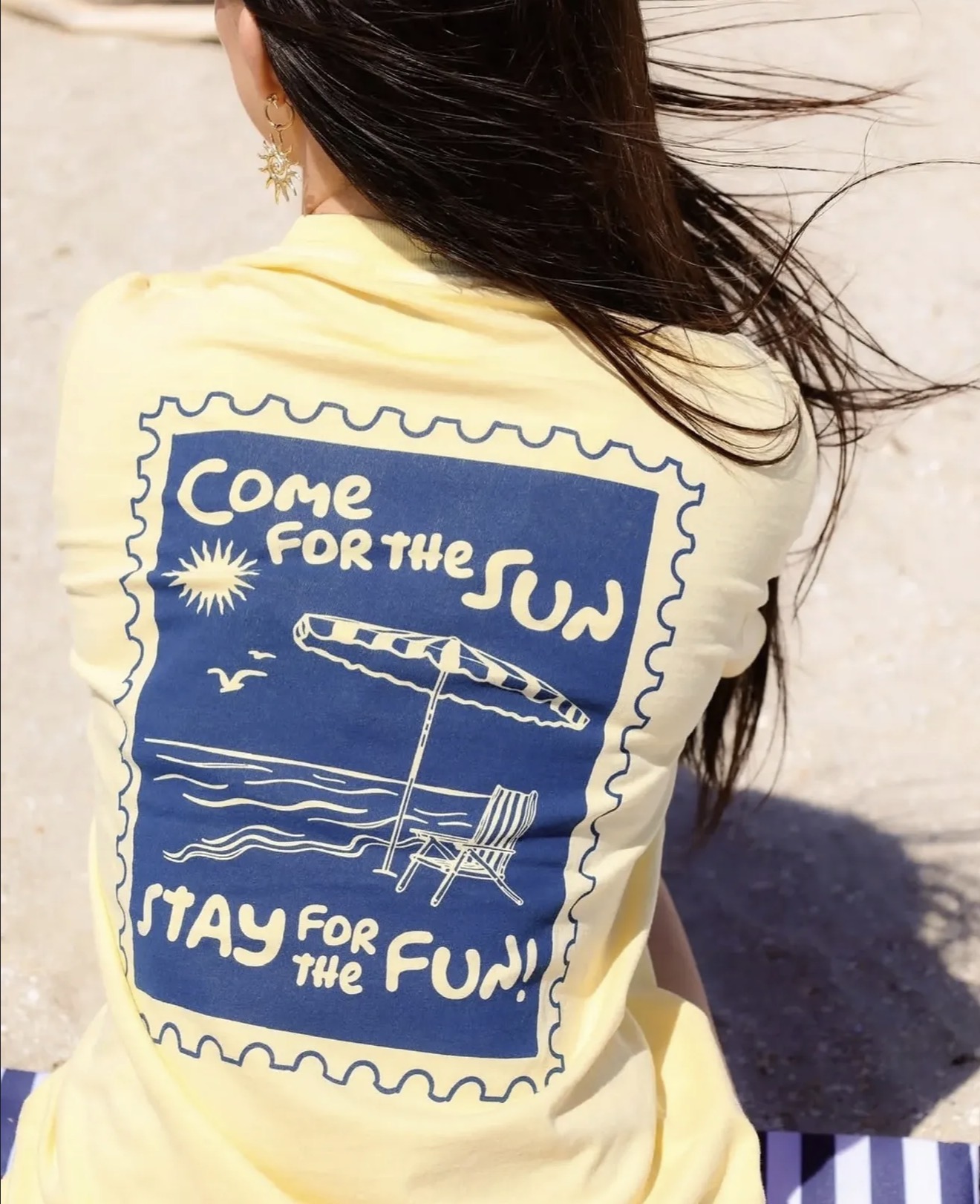 Model wearing a yellow Jackpot 'Come for the sun, stay for the fun' graphic tee